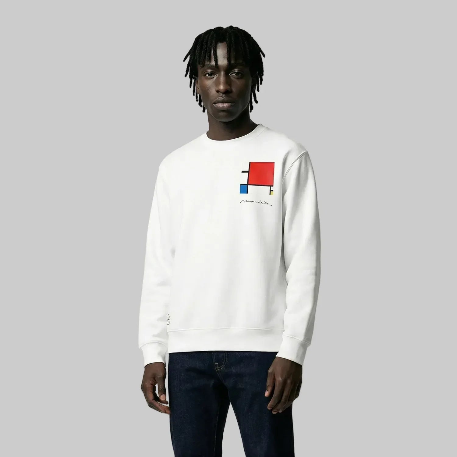 Person wearing a white sweatshirt with a colorful graphic design on a plain background