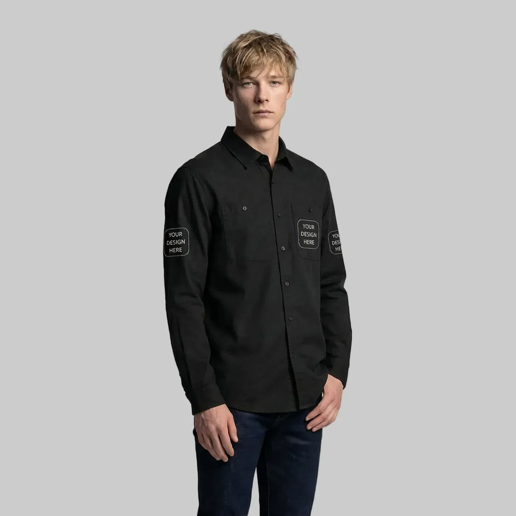 Man wearing a black shirt with customizable text patches on a plain background